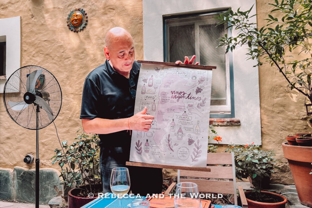 Host explaining Argentine wine regions using a visual guide during Asado Adventure, adding context to the asado experience in Buenos Aires.