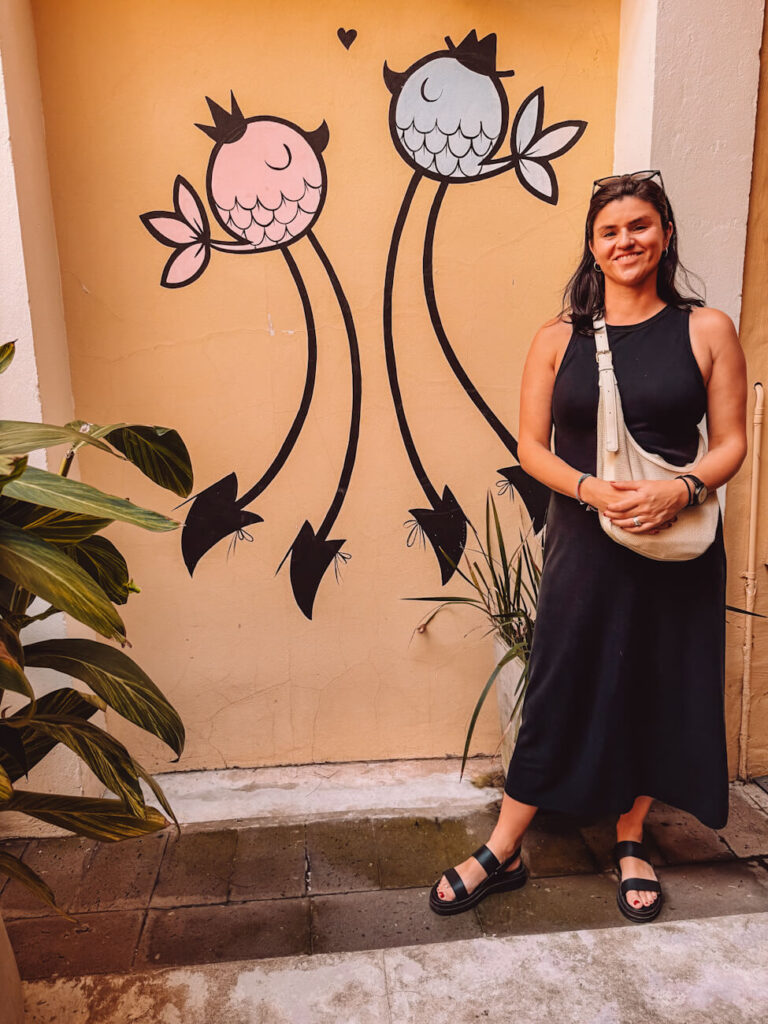 A woman (the author of this article) standing beside colourful mural during the Asado Adventure experience in Buenos Aires.