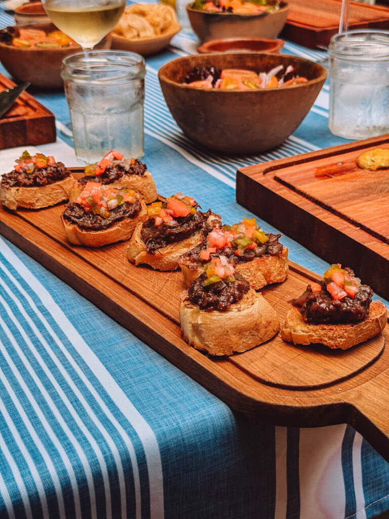 Crispy crostini topped with morcilla (blood sausage) and salsa served as a starter at Asado Adventure, an Argentine barbecue experience in Buenos Aires.
