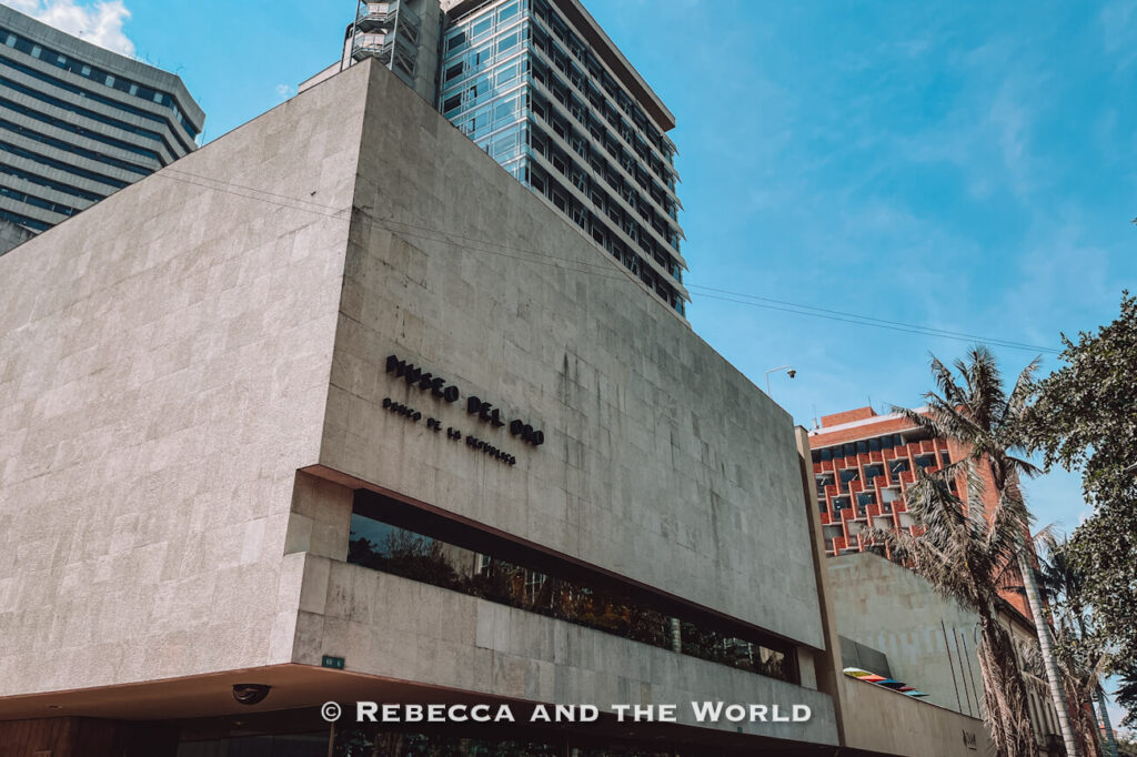 Modern stone-clad building with “Museo del Oro” signage viewed from the street with high-rise buildings behind it, a must-see during 48 hours in Bogotá.