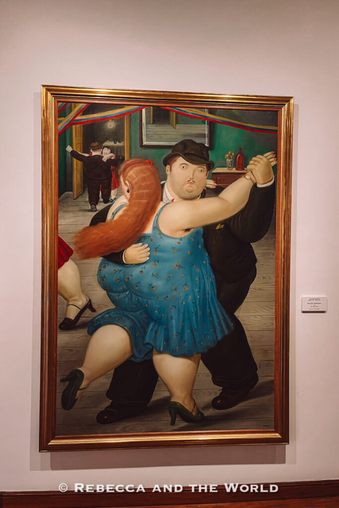 Framed painting of a dancing couple with exaggerated proportions displayed on a museum wall, showcasing artwork by Fernando Botero and what to do in Bogotá.