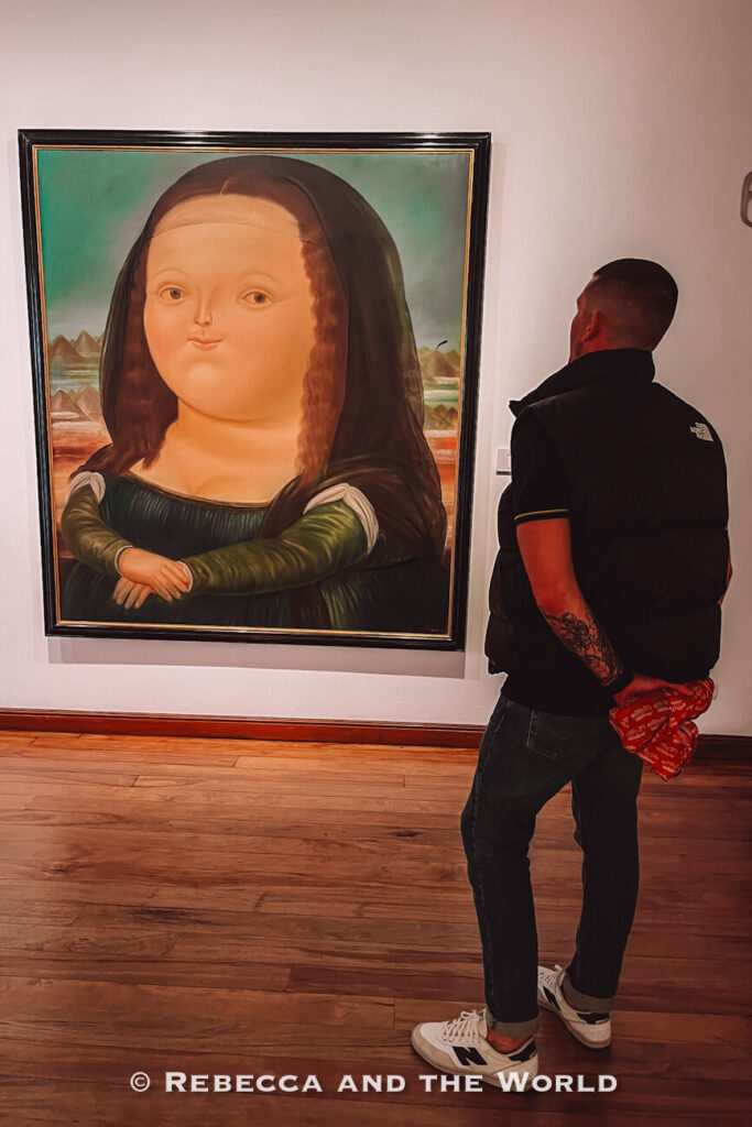 Visitor standing in front of a large Botero-style Mona Lisa painting inside a museum gallery with wooden floors and white walls during 2 days in Bogotá.