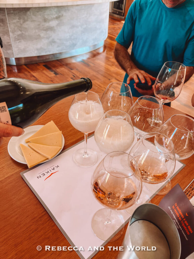 Several glasses being filled with sparkling wine beside plates of cheese during a seated tasting experience. Featured in many wine tasting in Mendoza experiences.