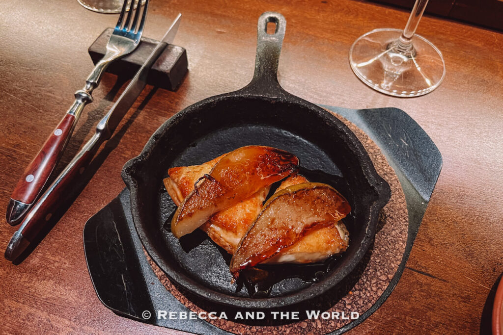 Cast iron pan with provoleta topped with seared pears at Fogon Asado in Buenos Aires.