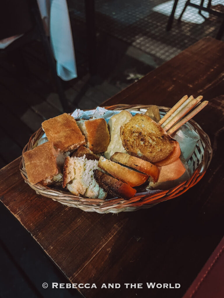 A basket of assorted breads, toasted slices, and breadsticks served as a starter at a traditional steakhouse in Buenos Aires.