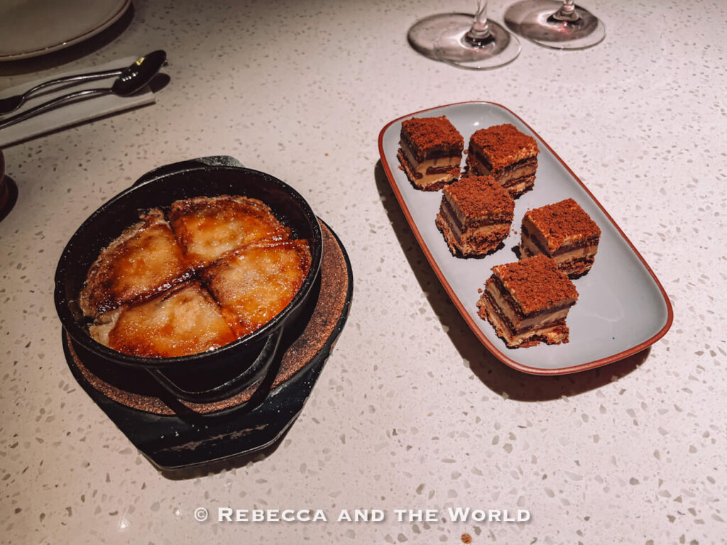 Dessert spread at The Argentine Experience in Buenos Aires featuring a skillet of pancakes with dulce de leche and a plate of layered chocotorta cakes on a white stone counter, part of a memorable Buenos Aires itinerary.
