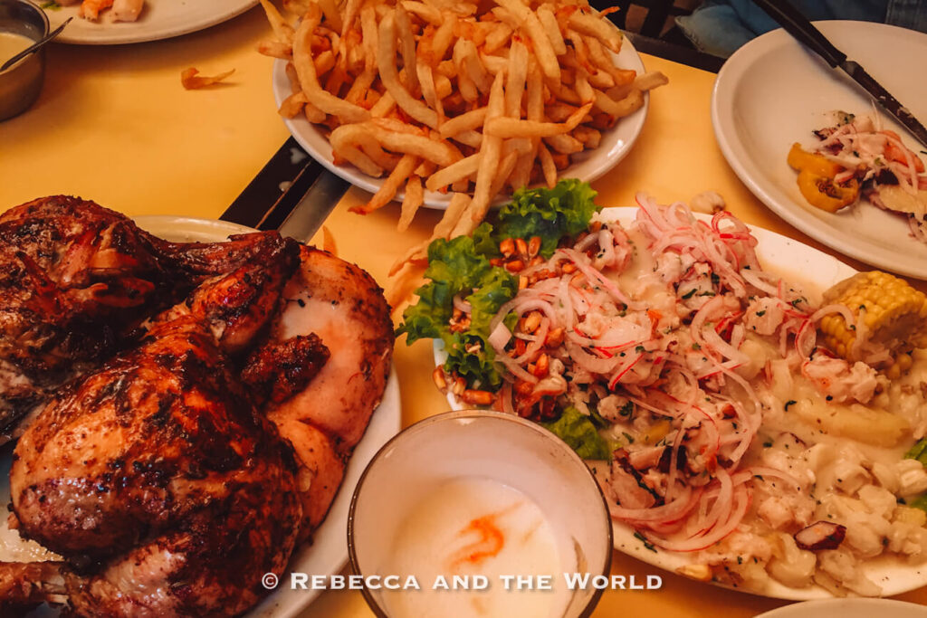 Large restaurant table spread featuring roasted chicken, a towering plate of French fries, ceviche topped with sliced red onions, grilled corn, and creamy potatoes. The colorful shared dishes capture the lively food culture and variety of Buenos Aires restaurants.
