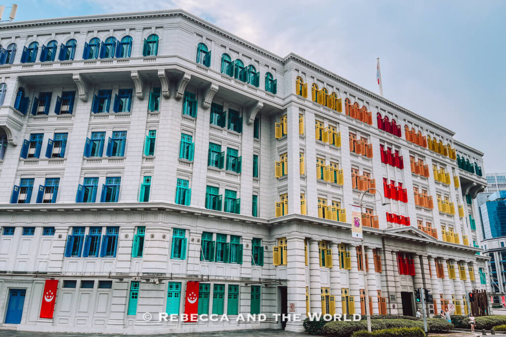 Colourful blue, turquoise, yellow, orange and red window shutters cover the white façade of the historic Old Hill Street Police Station in central Singapore.