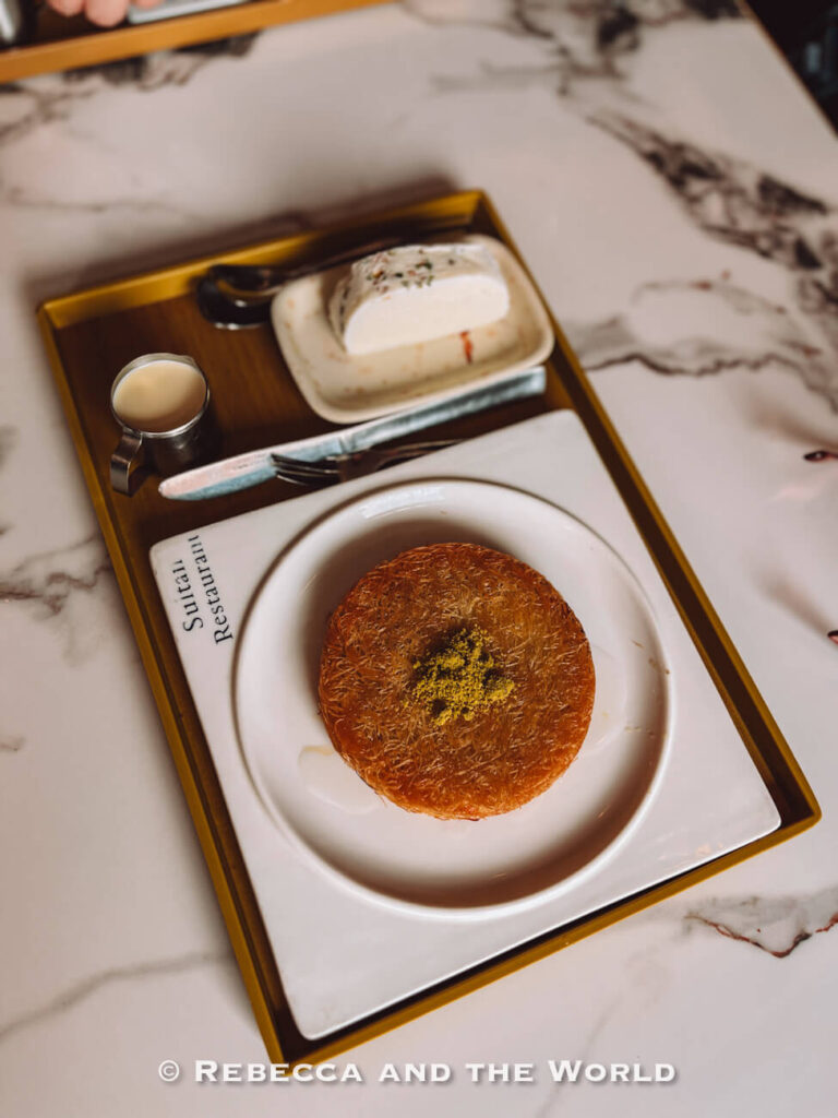 Round knafeh pastry topped with crushed pistachios and served with ice cream at Sultan Turkish Restaurant, a sweet stop on a Singapore itinerary.