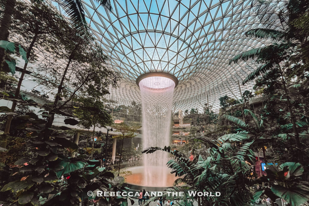 HSBC Rain Vortex cascading from the glass-domed roof into a lush indoor garden at Jewel Changi Airport, a memorable stop on a Singapore itinerary.