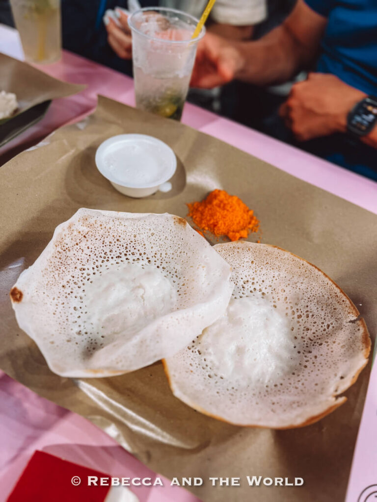 Two lacy-edged appam pancakes served with coconut milk and orange sugar, a South Indian dish tried on the Singapore chef's tour