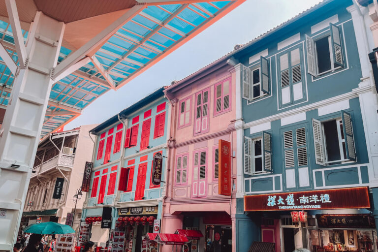 Colourful heritage shophouses with red, pink and grey-green façades and traditional shuttered windows along Smith Street in Singapore’s Chinatown.