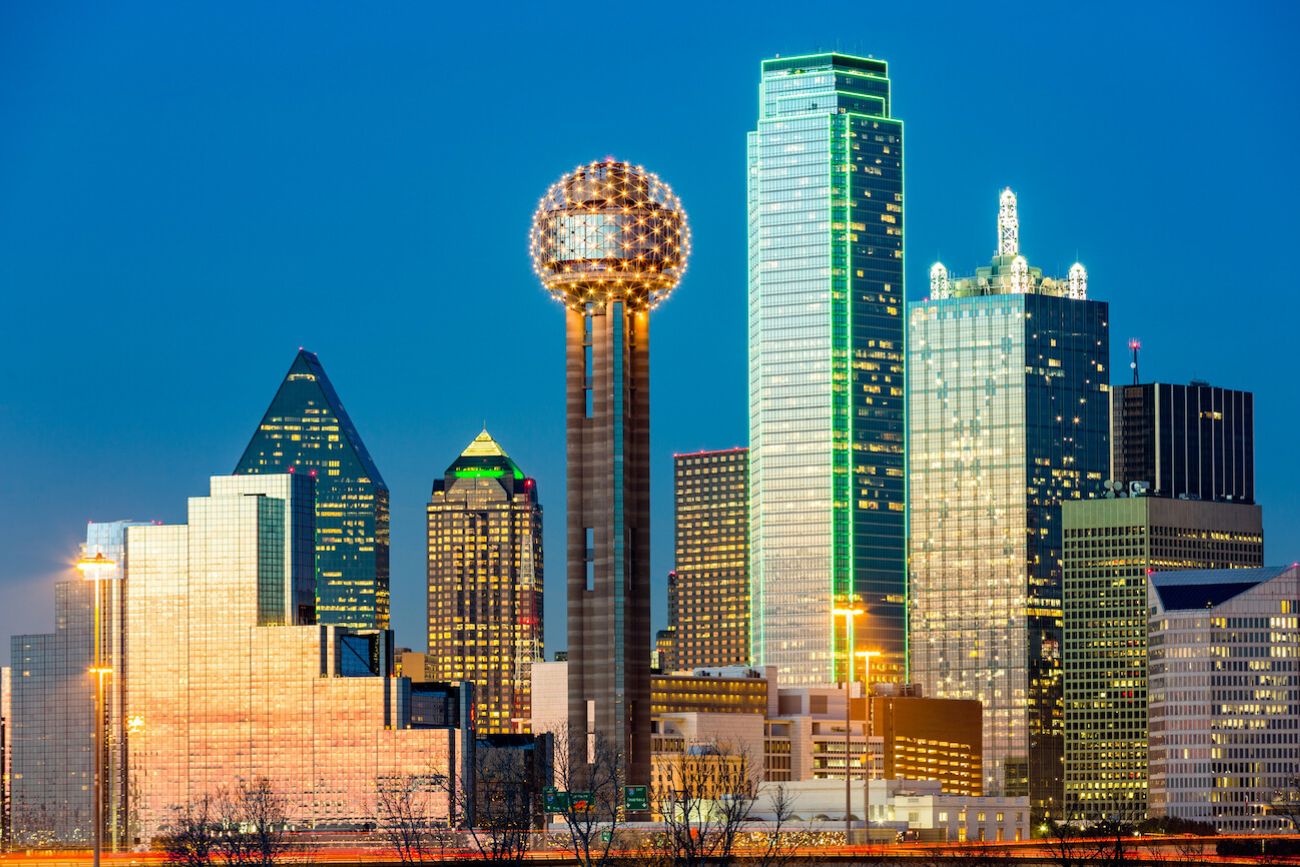 Downtown Dallas skyline at night with the illuminated Reunion Tower, a landmark to keep in mind when deciding where to stay in Dallas near Downtown hotels.