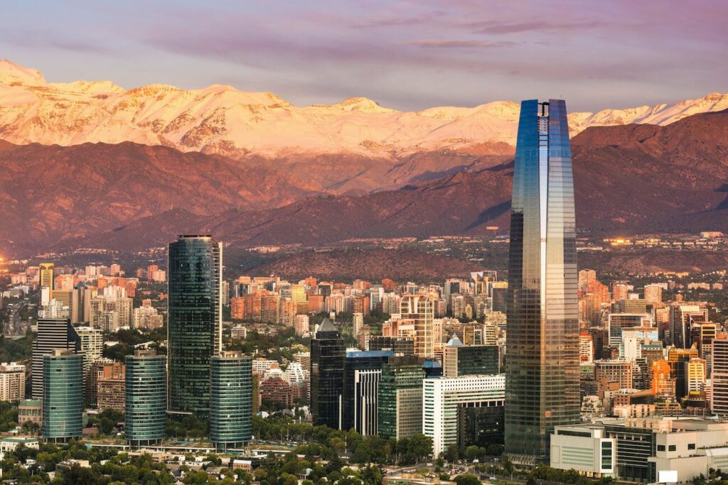 Santiago, Chile skyline at sunset with the Gran Torre Santiago and Las Condes high-rises set against the snow-capped Andes, the view that makes choosing where to stay in Santiago, Chile so worthwhile.